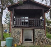 A wooden cottage in Bohdanovce with a basement and garden surroundings.