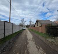 A rural road in Bohdanovce, with residential plots on both sides of the street.