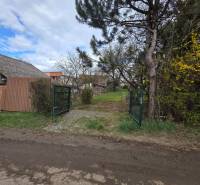A gate surrounded by greenery and a fence on residential land in Bohdanovce.
