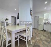 A kitchen in a family house with a wooden decor floor and white furniture.