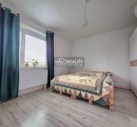 Bedroom with wood-patterned flooring, a bed, and a built-in wardrobe in a family house.