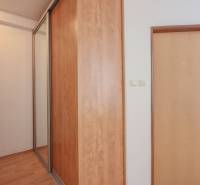 Interior of a 2-room apartment with a sliding wardrobe and a floor with a wooden decor.