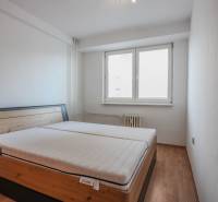 Bedroom with a bed and wooden decor flooring in a 2-room apartment.