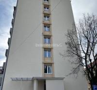 Apartment building in Prievidza on T. Vansovej Street, where an orange car is parked.