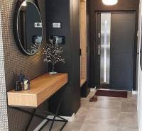 Entrance hall with a round mirror, wooden console, and decorative elements in a family house.