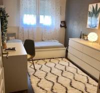 Children's room with a desk, carpet, and wooden decor flooring in a family house.