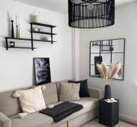 Living room in a family house with a comfortable sofa, decorative shelves, and a modern chandelier.