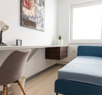 A workspace in a 4-room apartment with a sofa and a table on a light floor.