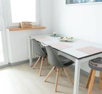 Dining area with a table and chairs in a 4-room apartment, floor with a wooden decor.