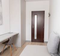 A workspace in a 4-room apartment with a wooden decor floor and modern art.