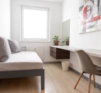 A room in a 4-room apartment with a bed, a table, and a floor with a wooden decor.
