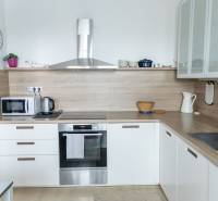 A kitchen with built-in appliances in a 4-room apartment, floor with wood decor, light-colored cabinetry.