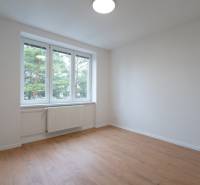 A bright room with white walls and a floor with a wood decor in a 3-room apartment.