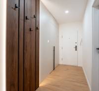 A narrow hallway with built-in cabinets and a wooden-patterned floor in a 3-room apartment.