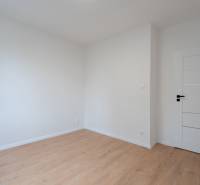 A room in a 3-room apartment with a wooden decor floor and white walls.