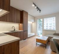 Living room in a 3-room apartment with a kitchen unit and a wooden decor floor.
