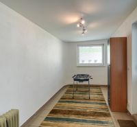 A narrow room with carpet, table football, and furniture in a 3-room apartment.