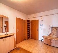 Hallway in a 3-room apartment with tiles, a built-in wardrobe, and wooden furniture.