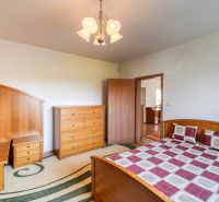 Bedroom in a 3-room apartment with wooden furniture and a bed with a checkered throw.