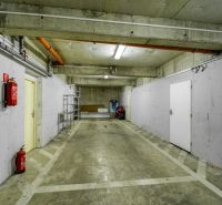 Underground garage with a parking space and fire extinguishers in a 3-room apartment.