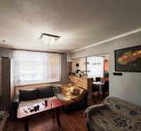 Living room with a sofa set, wooden decor flooring, and a light chandelier in a 4-room apartment.
