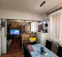 Dining room in a 4-room apartment with a wood-patterned floor and a television.