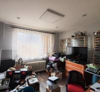 A room in a 4-room apartment with a wood-patterned floor and plenty of storage boxes.