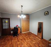 A room in a 4-room apartment with a wooden decor floor and a desk.