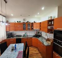 A kitchen unit with a wooden decor, a gas stove, and a dining table, in a 4-room apartment.