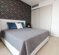 Bedroom with a bed, patterned wall, wooden decor flooring, 2-room apartment.