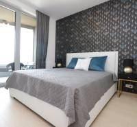 Bedroom with a bed, wallpaper, and access to a balcony in a 2-room apartment.