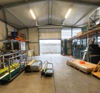 Commercial premises with stored material and an open gate, the floor has a concrete surface.