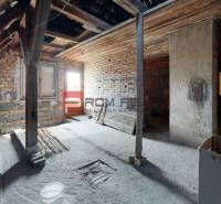 An unfinished attic space with wooden beams in a family house.