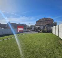 The garden of a family house on Chorvátska Street in Slovenský Grob with a lawn and a fence.