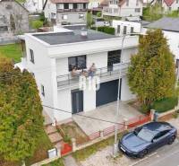 A family house in Martin with a balcony, garage, and surrounding greenery.