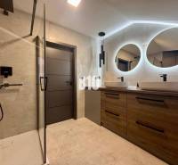 A bathroom in a 4-room apartment with two oval mirrors and a shower corner.