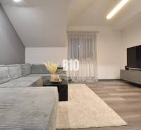 Living room with a corner sofa, television, and wooden decor flooring in a 4-room apartment.
