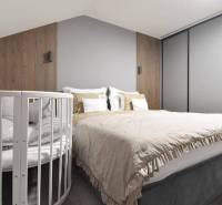 A bedroom with a bed, a baby crib, wooden decor, and neutral colors in a 4-room apartment.