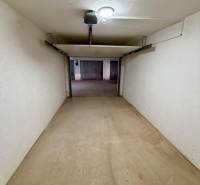Closed garage space with a concrete floor and lighting.
