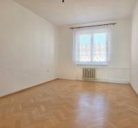 An empty room with a window and a wooden decor floor in a 3-room apartment.