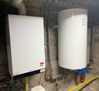 Boiler with a water heater in the boiler room of a family house, including pipes and ducts.