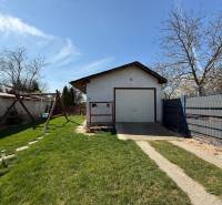 A family house in Zlaté Moravce with a lawn, a swing, and a garage on the property.