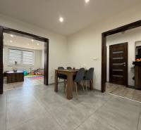 Interior of a family house with a dining table, children's room, and decorative flooring.