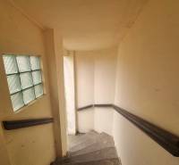 A staircase inside a family house with a glass wall and railing.