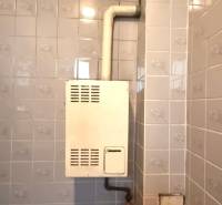 Bathroom in a family house with a gas boiler on tiles.