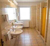 The bathroom in the building offers sinks and showers with a tiled floor.