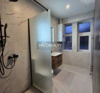 A bathroom in a 2-room apartment with a bathtub and a shower, tiles with marble imitation.