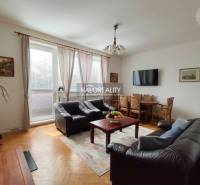 Living room with leather sofas and a television, with a wood-patterned floor.