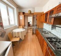 A kitchen in a 3-room apartment with a wooden decor floor and a dining table.