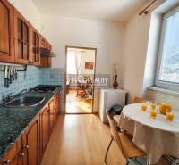 A kitchen in a 3-room apartment with wooden cabinets and a wooden decor floor.